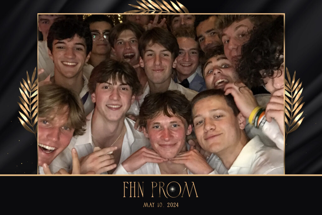 Group of students smiling in white shirts at FHN Prom May 10, 2024 photo booth with black and gold frame and decorative leaves