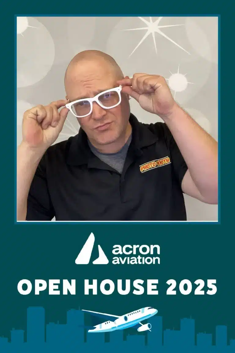 TJ from Fastbooth posing with white glasses at Acron Aviation Open House 2025 — photobooth activation with city skyline graphic.