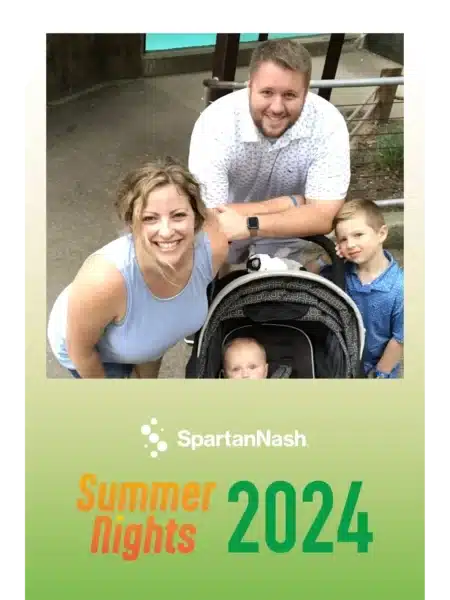 Family with a stroller posing outdoors at a FastBooth photo booth with teal door backdrop and SpartanNash Summer Nights 2024 overlay