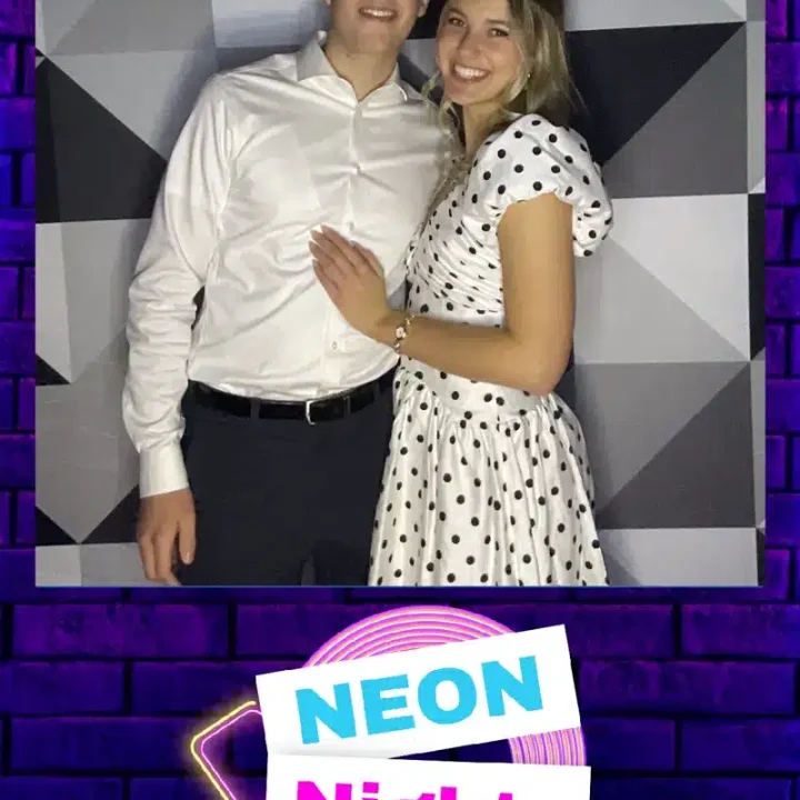 Prom couple posing in FastBooth photo booth at Neon Nights 2026 high school prom with geometric backdrop